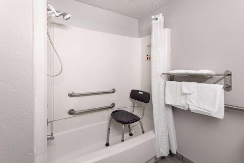 a bathroom with a shower with a chair in it at Super 8 by Wyndham Amarillo Central TX in Amarillo
