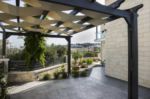 a pergola on a house with a patio at Villa-Azalea in Almirida