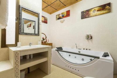 y baño con bañera y lavamanos. en Casa Rural La del Alba Sería, en Argamasilla de Alba
