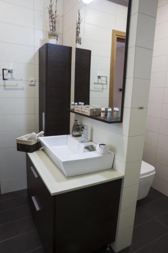 a bathroom with a sink and a mirror and a toilet at Villa-Azalea in Almirida