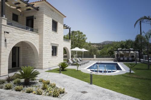 a house with a swimming pool in the yard at Villa-Azalea in Almirida
