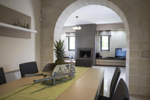 a dining room with a table and a living room at Villa-Azalea in Almirida