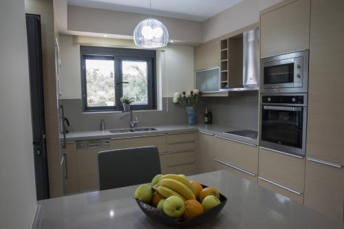 a kitchen with a bowl of fruit on a table at Villa-Azalea in Almirida