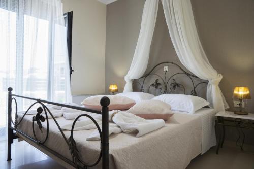 a bedroom with a bed with white sheets and pillows at Villa-Azalea in Almirida