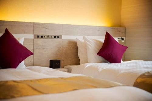 a hotel room with two beds with red pillows at Best Western Hotel Fino Tokyo Akasaka in Tokyo