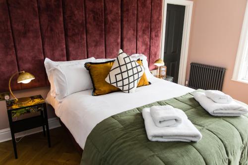 ein Schlafzimmer mit einem großen Bett mit Handtüchern darauf in der Unterkunft Dragon Villas by Maison Parfaite - Luxury Studios & Apartments - Harrogate in Harrogate