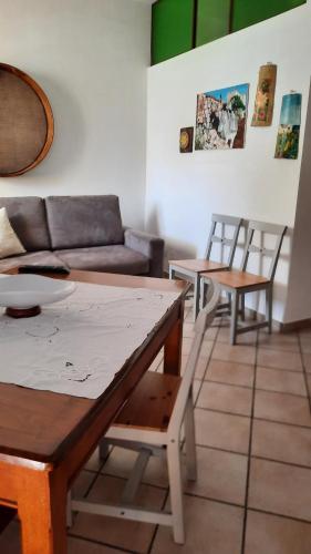 un soggiorno con divano, tavoli e sedie di Le Ciaramire a Favignana