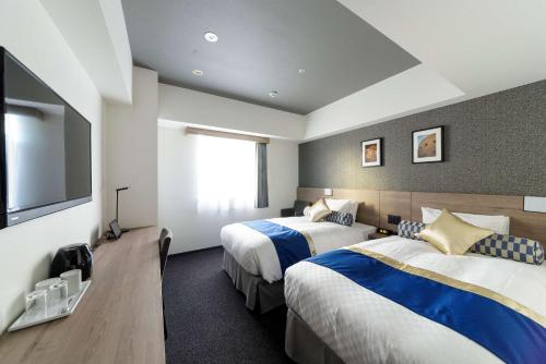大阪市にあるベストウェスタンプラスホテルフィーノ大阪北浜のベッド2台、薄型テレビが備わるホテルルームです。
