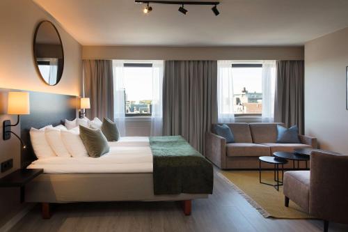 pokój hotelowy z łóżkiem i kanapą w obiekcie Scandic City w mieście Fredrikstad