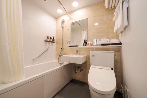 a bathroom with a toilet and a sink and a tub at Best Western Plus Fukuoka Tenjin-minami in Fukuoka