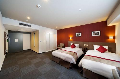 two beds in a hotel room with red walls at Best Western Plus Fukuoka Tenjin-minami in Fukuoka