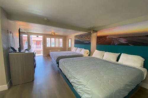 a large bedroom with two beds and a television at Super 8 by Wyndham Oceanside Downtown in Oceanside