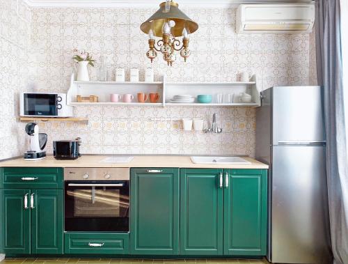 a kitchen with green cabinets and a refrigerator at Apartamento "Kanogal" in Labastida