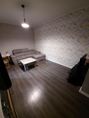 a living room with a couch and a table at Futuristic 1 Bedroom Apartment next to Vake Park in Tbilisi City