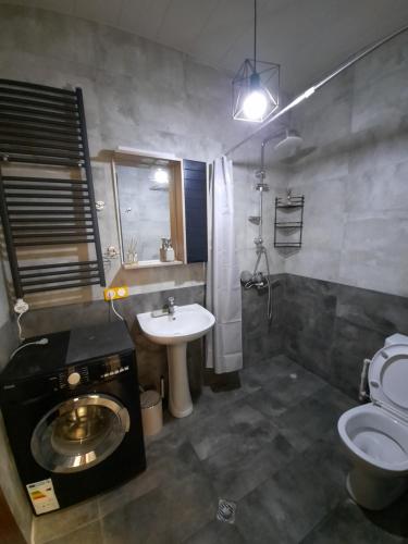 a bathroom with a sink and a toilet and a sink at Futuristic 1 Bedroom Apartment next to Vake Park in Tbilisi City