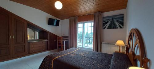 a bedroom with a bed and a large window at Casa Angelina in O Grove