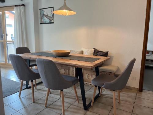 einen Esstisch mit Stühlen und eine Schüssel darauf in der Unterkunft Apartment Residenza Chesa Margun 13-4 by Interhome in Surlej