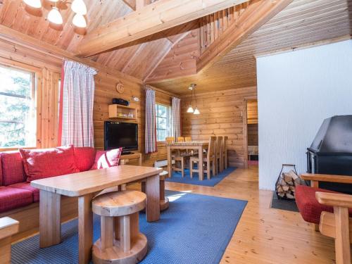 ein Wohnzimmer mit einem roten Sofa und einem Tisch in der Unterkunft Holiday Home Uolevintie 39a by Interhome in Ruka