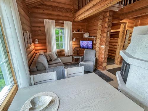 uma sala de estar num chalé de madeira com um sofá e uma televisão em Holiday Home Vuosselinkulma 2 by Interhome em Ruka
