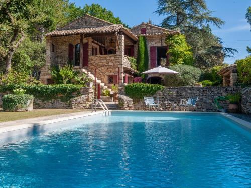 a house with a swimming pool in front of a house at Holiday Home La Réalière by Interhome in Beaumettes