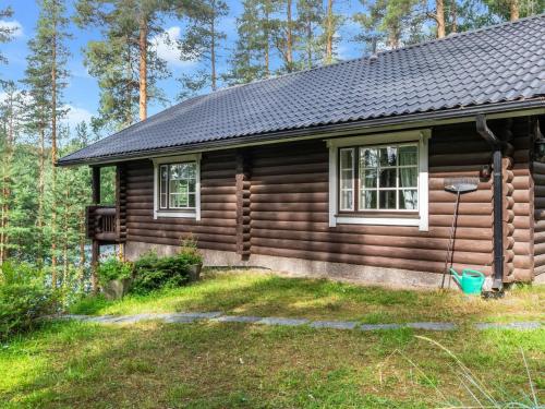 una cabaña de madera con un patio delante en Holiday Home Sarvitupa by Interhome en Kangashäkki