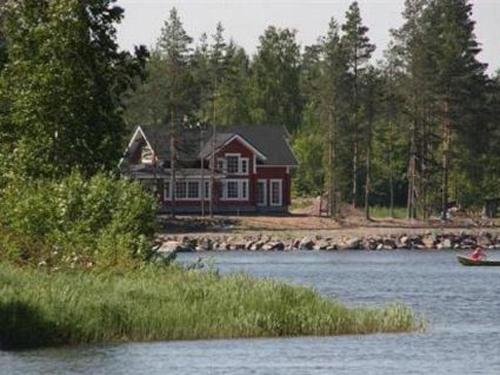 uma casa na margem de um lago com um barco em Holiday Home Pernoo 3 by Interhome em Pernoo