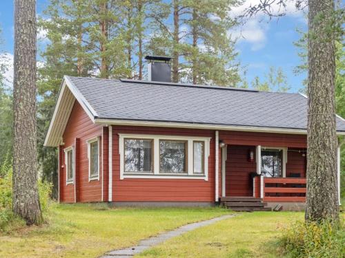 uma pequena casa vermelha na floresta em Holiday Home Lepokunnas by Interhome em Suomussalmi