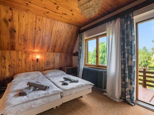 ein Schlafzimmer mit einem Bett in einem Zimmer mit Holzwänden in der Unterkunft Holiday Home Jestřebice 8 by Interhome in Dobřeň