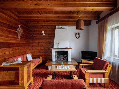 ein Wohnzimmer mit einem Sofa und einem Kamin in der Unterkunft Holiday Home Jestřebice 8 by Interhome in Dobřeň