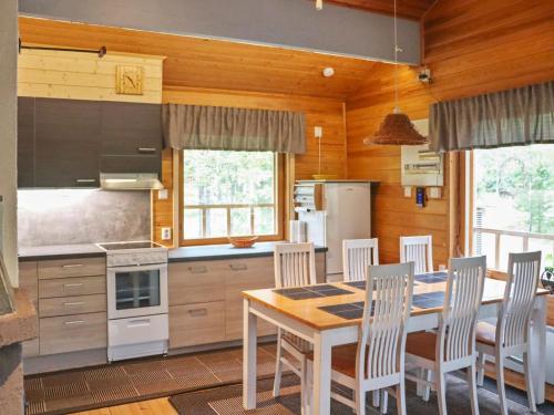a kitchen with a table and chairs in a room at Holiday Home Hyryn herra cottage by Interhome in Hyrynsalmi