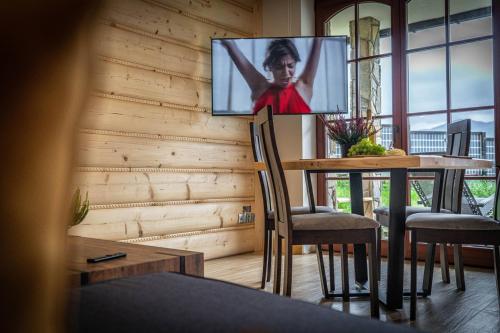 a room with a table with a tv on the wall at Good Morning Giewont & JACUZZI in Kościelisko