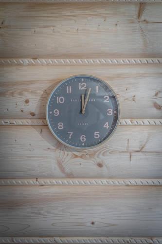 a clock is hanging on a wooden wall at Good Morning Giewont & JACUZZI in Kościelisko