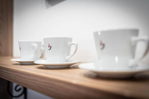 three coffee cups and saucers on a wooden shelf at Good Morning Giewont & JACUZZI in Kościelisko