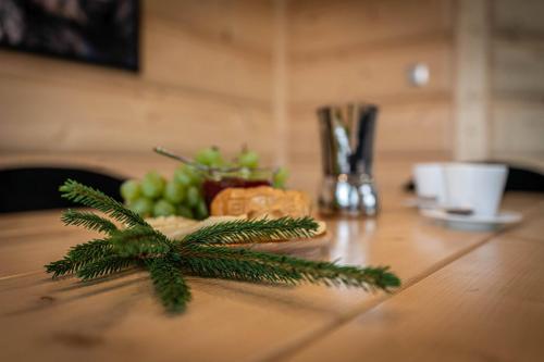 a table with a plate of food and a pine branch at Good Morning Giewont & JACUZZI in Kościelisko