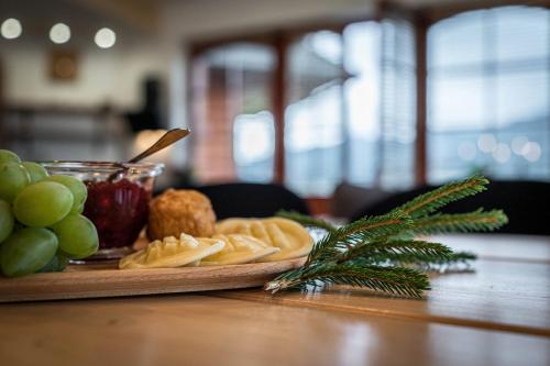 a plate of cheese and grapes on a table at Good Morning Giewont & JACUZZI in Kościelisko