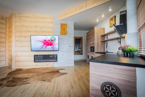 a kitchen with a counter and a tv on a wall at Good Morning Giewont & JACUZZI in Kościelisko