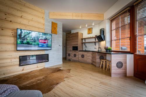 a living room with a flat screen tv on a wall at Good Morning Giewont & JACUZZI in Kościelisko