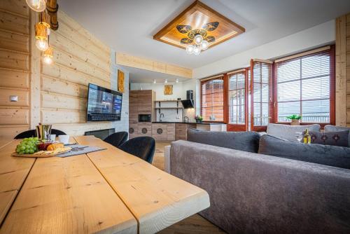 a living room with a wooden table and a couch at Good Morning Giewont & JACUZZI in Kościelisko