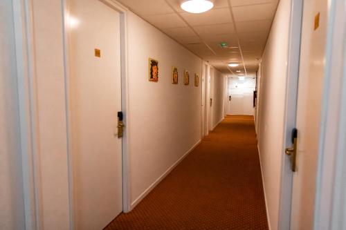 a corridor in an office building with white walls and a long hallway at Ambassador City Centre Hotel in Haarlem