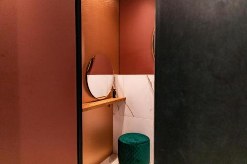 a bathroom with a mirror and a green stool at Ambassador City Centre Hotel in Haarlem