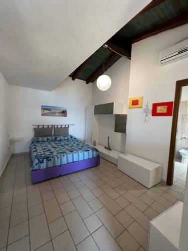 a bedroom with a bed and a tub in a room at Bilocale Acquamarina presso i nidi dei cormorani in Costa Rei