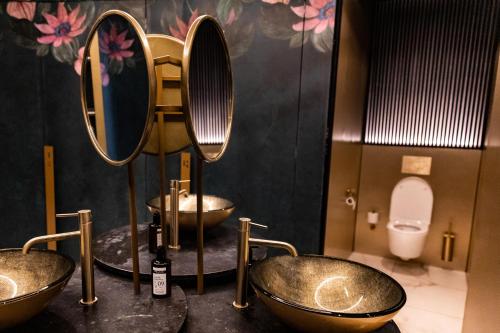 a bathroom with three sinks and a toilet at Ambassador City Centre Hotel in Haarlem