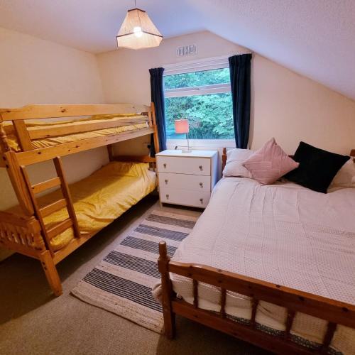 a bedroom with two bunk beds and a window at 19 the Coombe in Bude