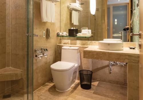 a bathroom with a toilet and a sink and a shower at Holiday Inn Bangkok by IHG in Bangkok