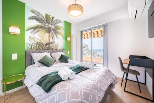 una camera da letto con un letto con pareti verdi e una scrivania di Baie de Monaco, Vue Mer, Terrasse, Parking Gratuit - AF a Beausoleil