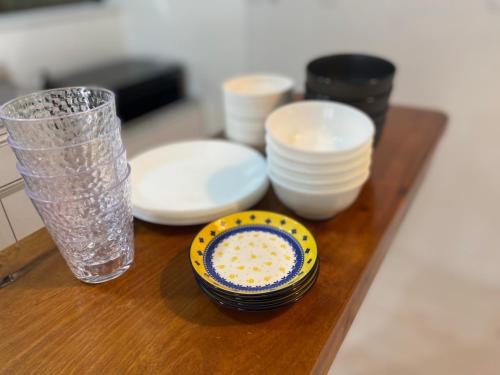a wooden table with plates and a bowl and a glass at Lanikai kujukuri in Chosei