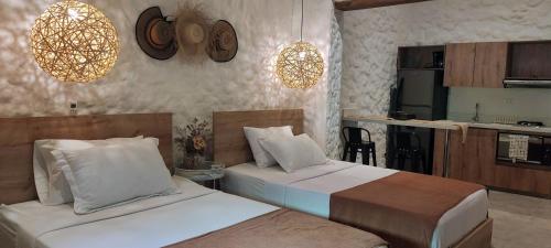 a hotel room with two beds and a kitchen at La Casa de Nelly - Medellín in Medellín