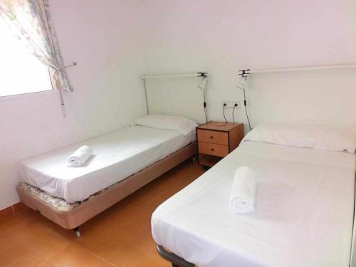2 Einzelbetten in einem Zimmer mit Fenster in der Unterkunft apartamento 46A VORA 2 dormitorio in Calpe