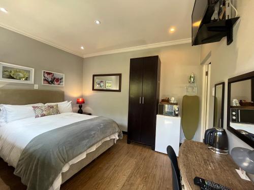 a bedroom with a bed and a table and a kitchen at ilanda Guest House in White River