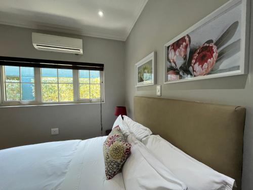 a bedroom with a white bed and two windows at ilanda Guest House in White River